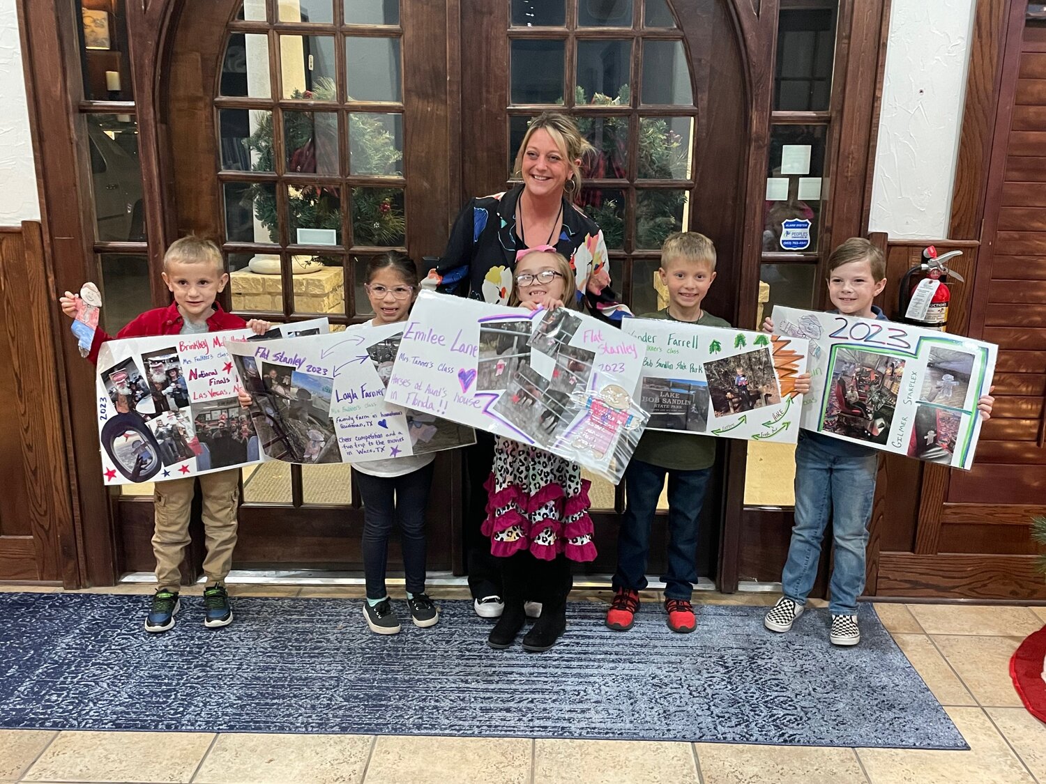 Connie Russell, Quitman ISD librarian, with first-graders who presented to the school board last week about their Flat Stanley poster projects.